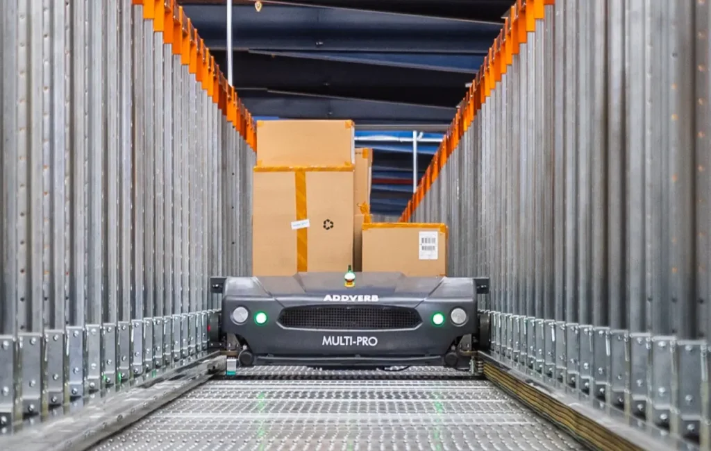 Multi-Pro ASRS shuttle carrying cardboard boxes inside a high-density warehouse racking system.