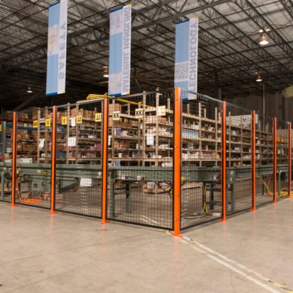 A fenced-off area inside a large warehouse with tall shelves filled with boxes and labeled sections. The flooring is concrete, and ceiling banners hang above the storage area.