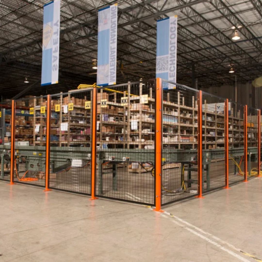 Wire mesh security enclosure with orange posts surrounding conveyor equipment in a distribution center