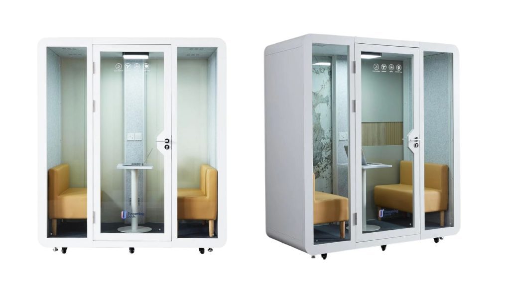 Two modern soundproof office pods with glass doors and white frames, each containing a small table, outlet, and yellow cushioned seats, shown from front and angled side views against a white background.