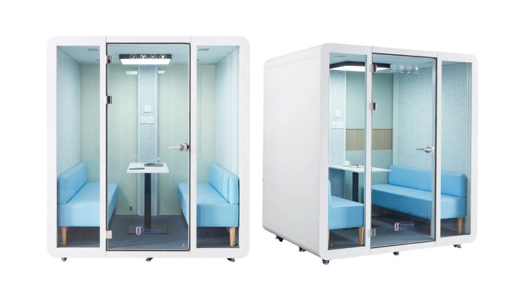 Two white, glass-enclosed office pods with blue cushioned benches inside, small tables, and bright interior lighting, shown from the front and at an angle on a white background.