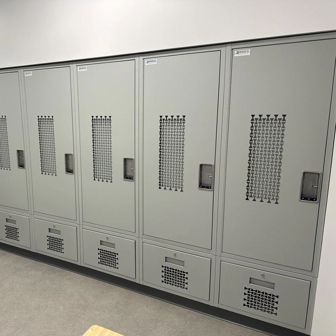 Row of gray double-tier steel corridor lockers with ventilated doors and recessed latches