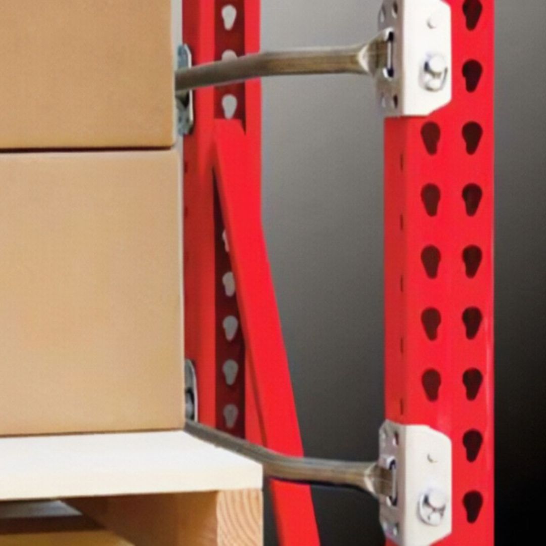Close-up of metal support braces attached to a red shelving unit holding stacked cardboard boxes. The background is plain and out of focus, emphasizing the importance of sturdy storage for optimal warehouse fire safety.