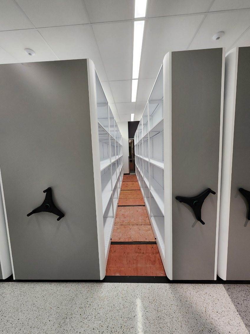 Interior aisle view of an installed high-density mobile shelving system in a laboratory records area