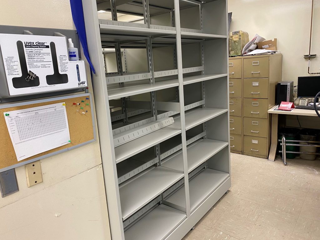 Shelving unit installed beside existing file cabinets and work surfaces in an occupied office