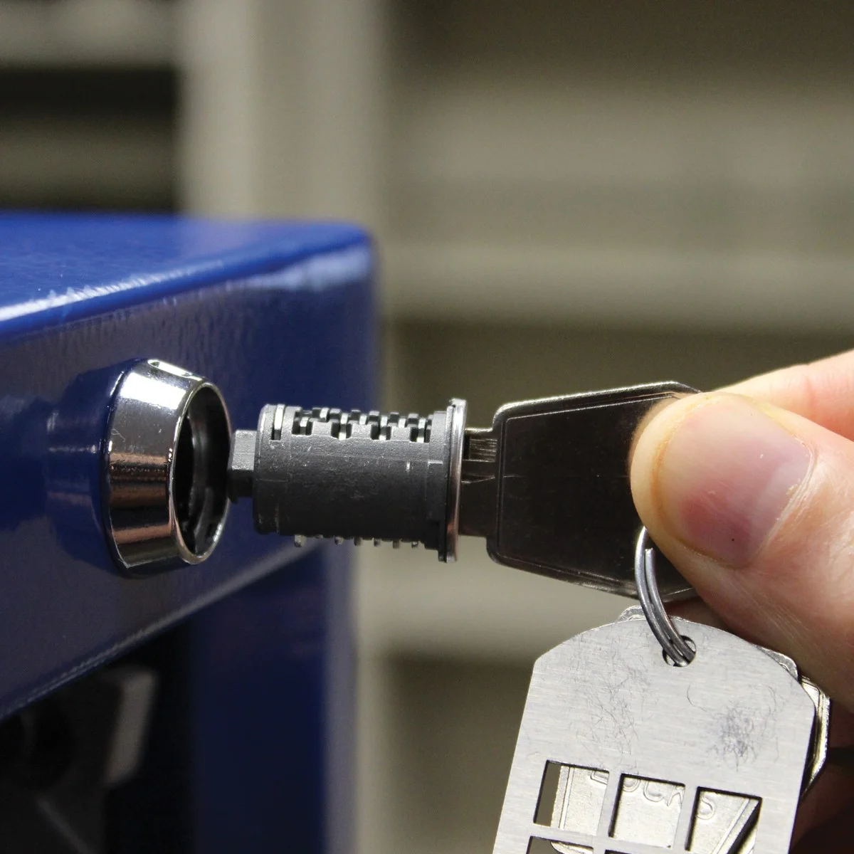 Close-up of a key lock cylinder on a blue Borroughs modular drawer cabinet