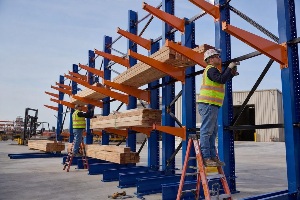 Workers installing cantilever rack in industrial yard
