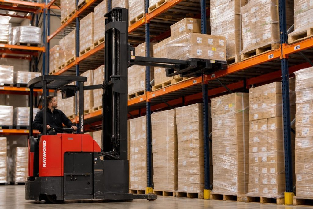Reach truck accessing rear position in double deep pallet rack