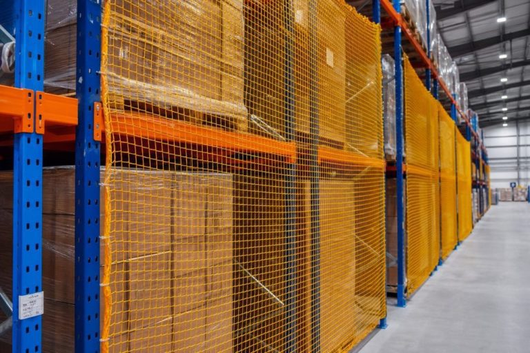 Pallet rack safety netting installed between pallet rack bays