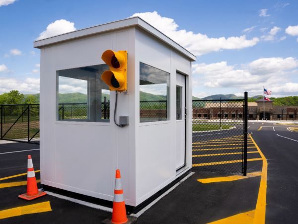 Prefabricated guard booth at a college campus vehicle entrance with signal head and crosswalk