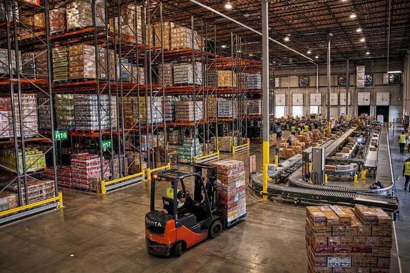 Push-back pallet rack in a busy distribution center with conveyorsand shipping docks