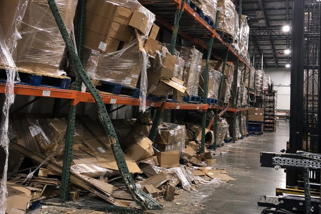 Severely damaged pallet rack upright from a forklift impact