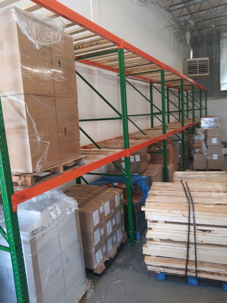 Tall pallet rack with rolling ladder and wire decking at corner of Sanmina warehouse