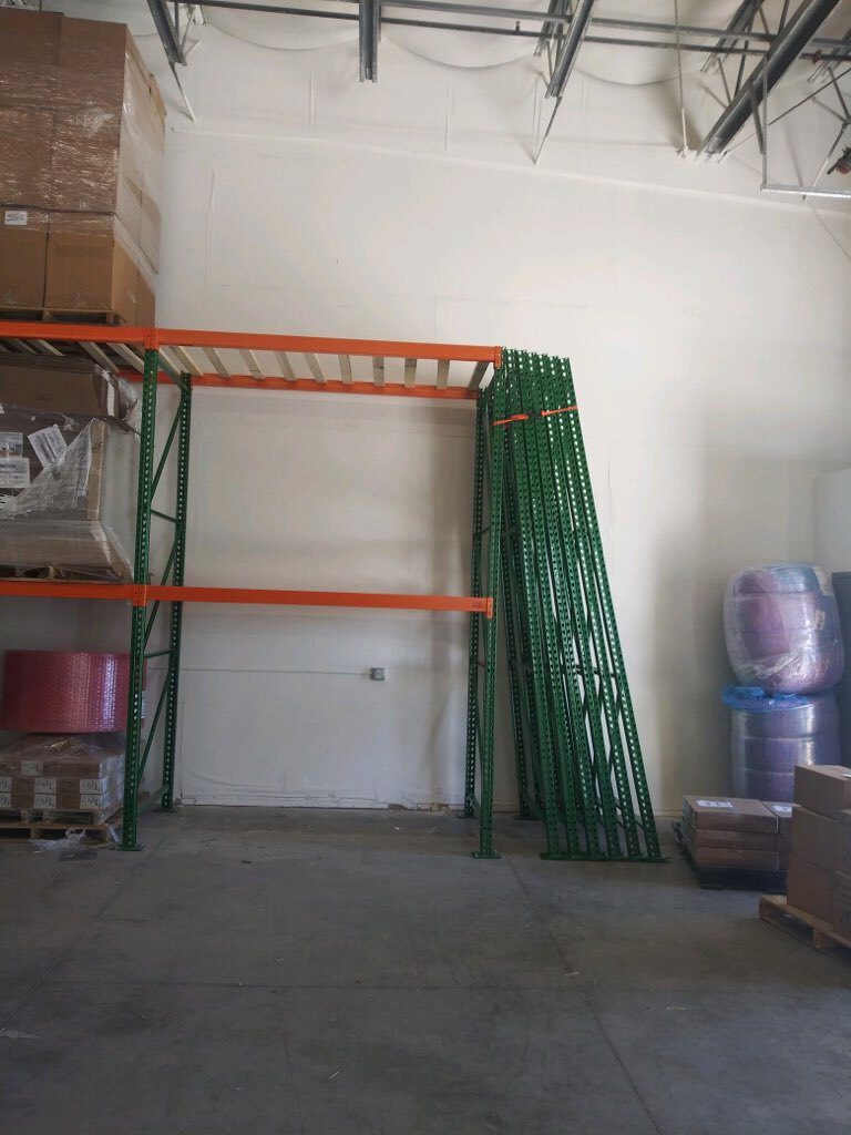 Perspective view of wall-run pallet rack shelving along concrete wall at Sanmina