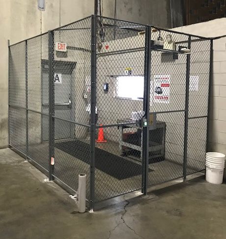 Gray driver access cage with bench seating at warehouse dock