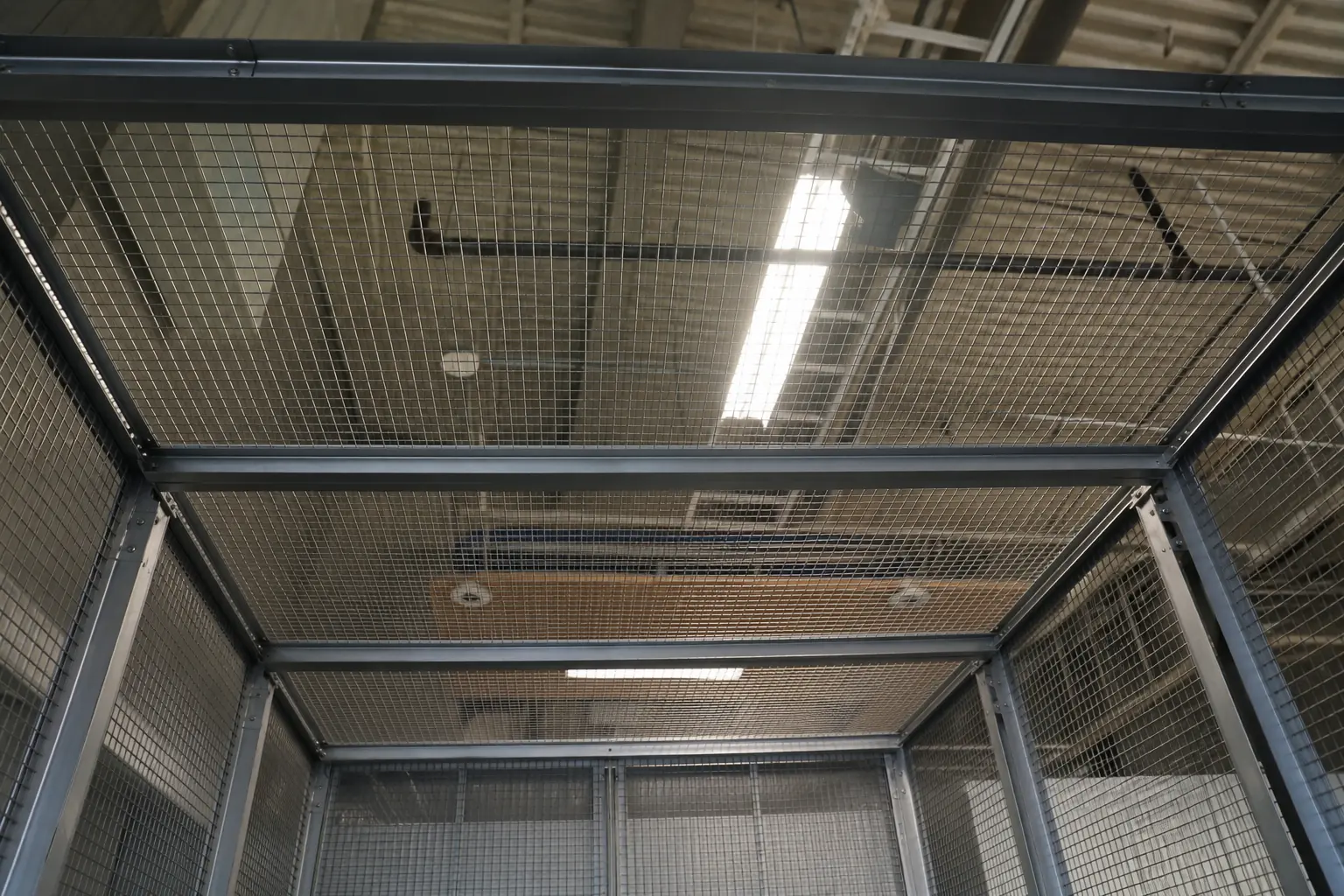 Welded wire mesh ceiling panels closing the top of a storage enclosure