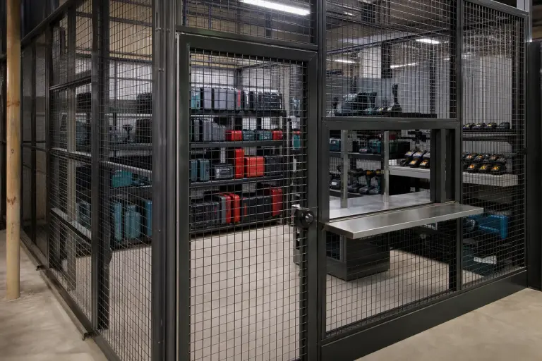 Tool crib security cage with a service window shelf and stocked tool shelving
