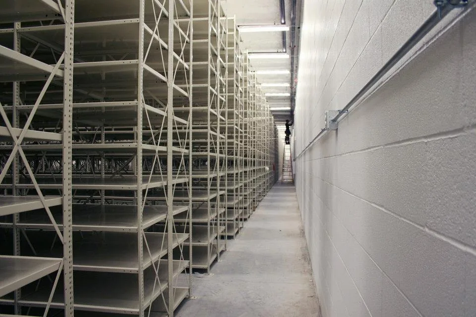 Open-back Penco Clipper shelving run along a wall in a military supply room