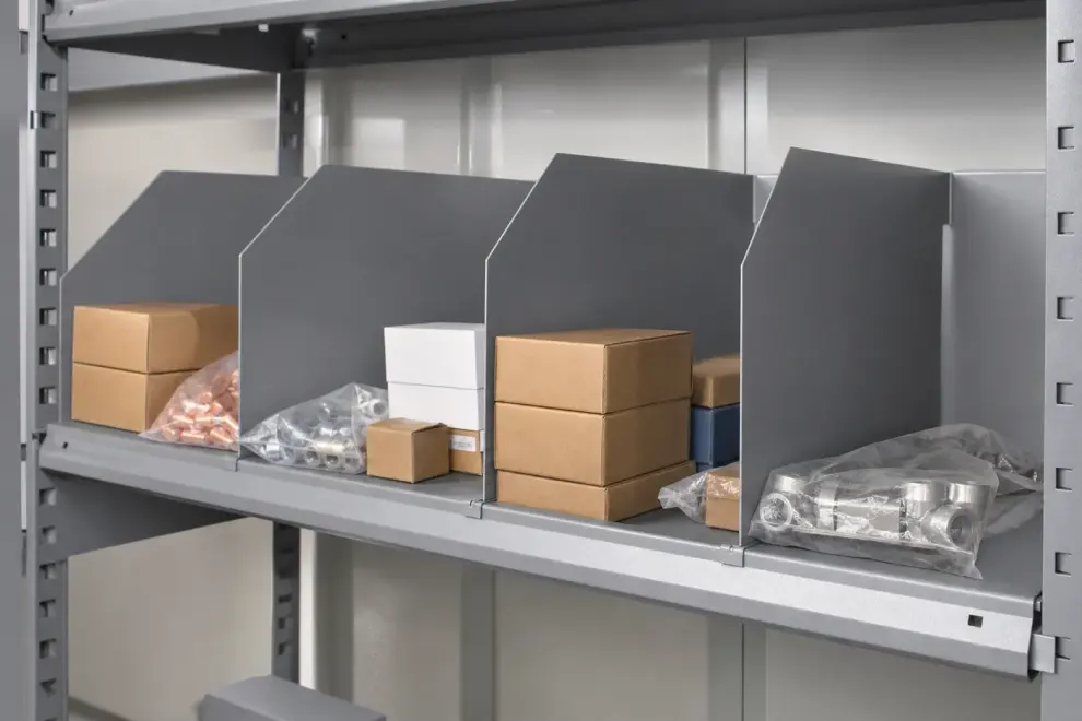 Steel shelf divided into separate compartments by sheet metal shelf dividers holding small parts
