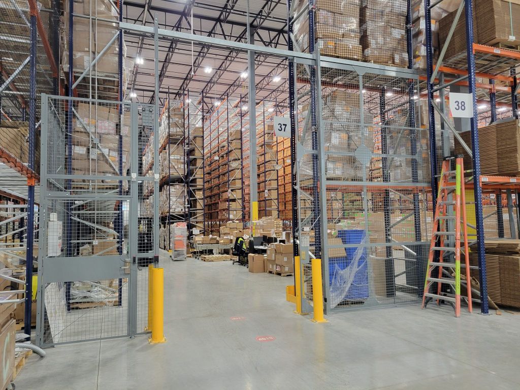 Large welded wire enclosure with a wide gate opening inside a service building