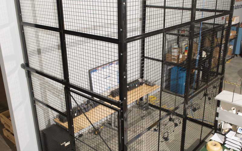Looking down into a tall wire mesh warehouse cage fitted with welded mesh ceiling panels