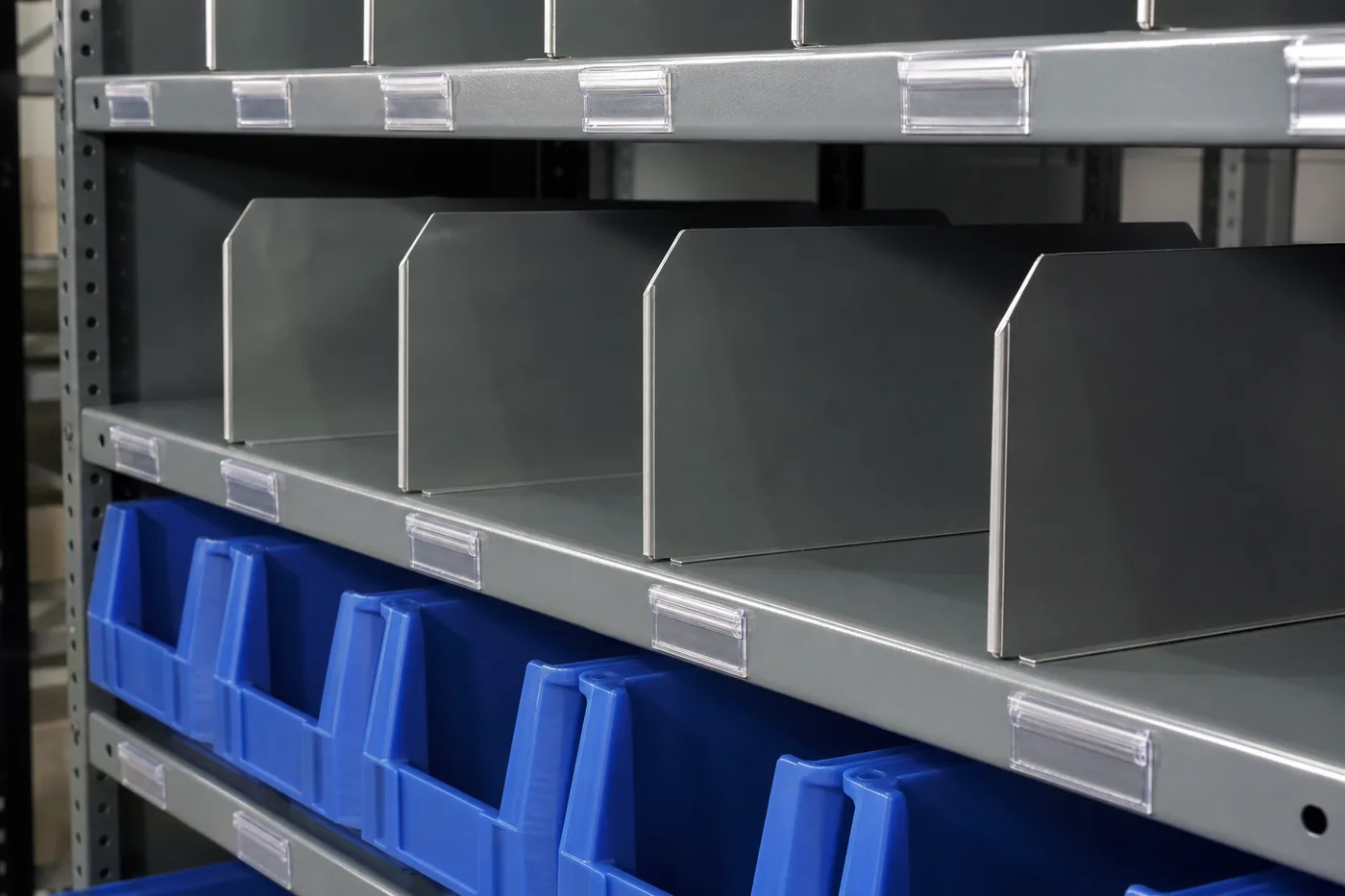 Steel shelf fitted with shelf dividers, label holders and a blue open-front plastic bin