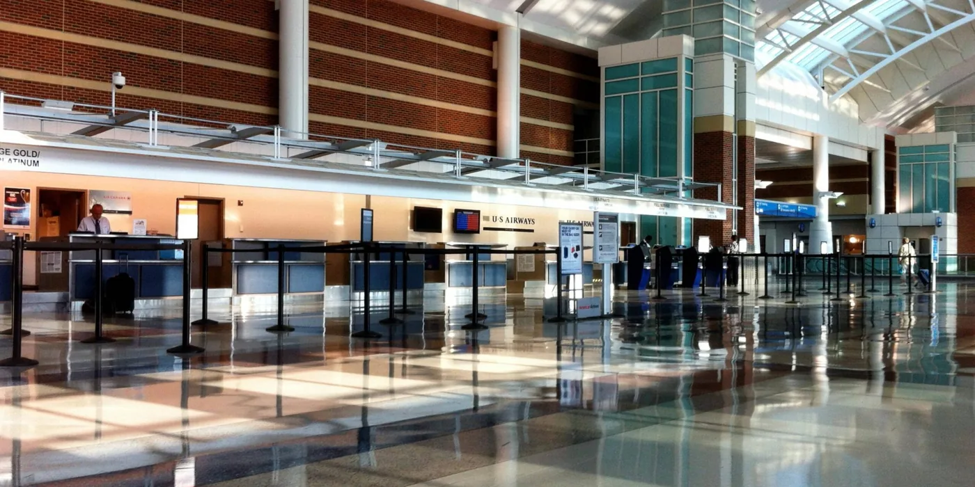 Bright airport terminal with passenger queue barriers and open circulation