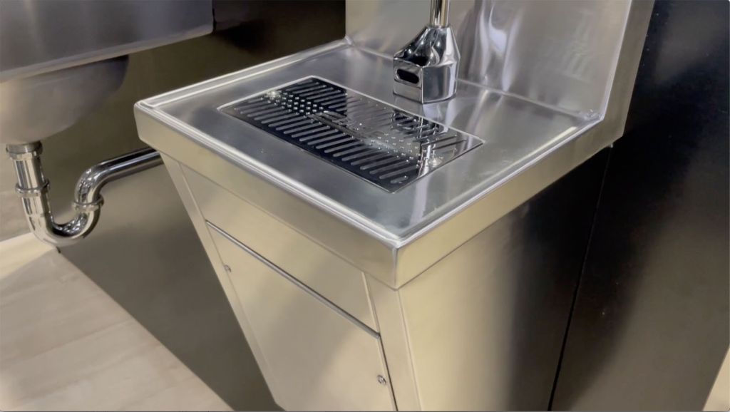 Bottle filler station with touch-free electronic-eye faucet and anti-splash grate