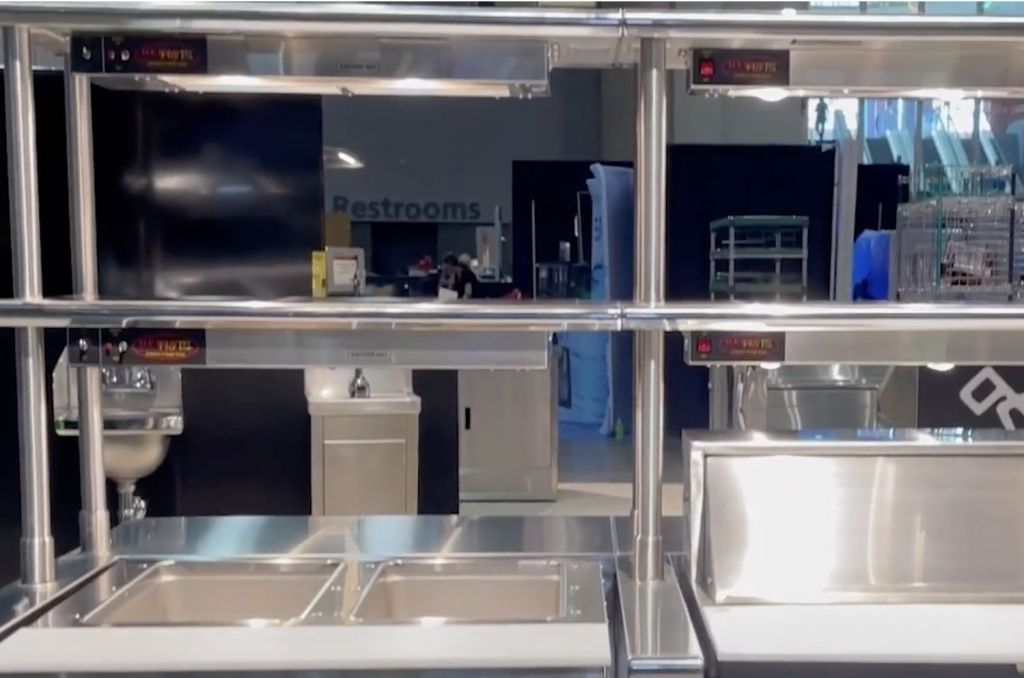 Heat lamps mounted over a mobile hot food holding counter