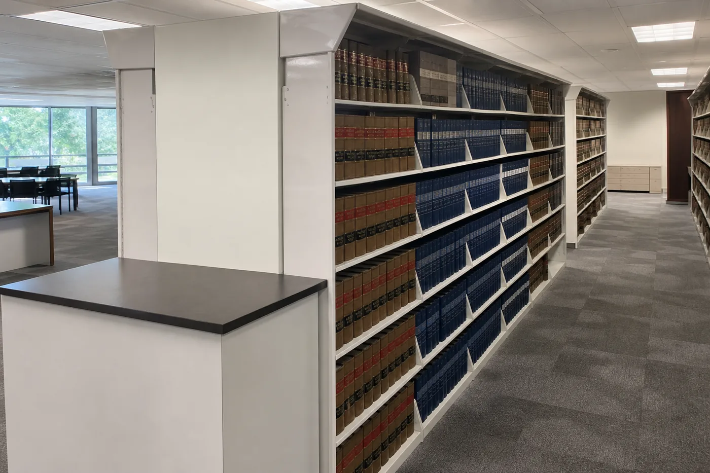 Government agency reference room with steel shelving ranges holding bound volumes