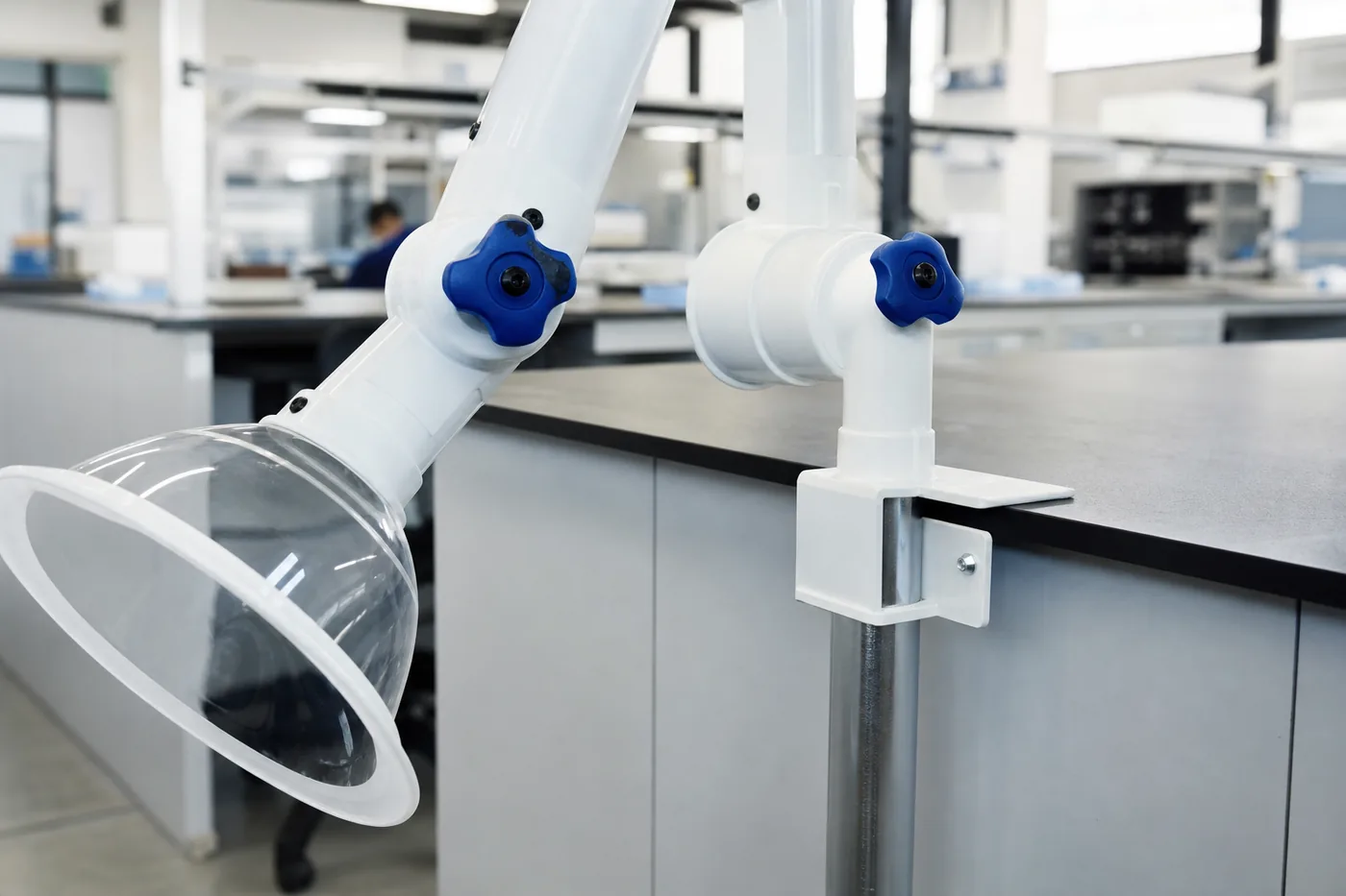 Bench-edge mounted articulated extraction arm on a laboratory worktop with the duct dropping behind the bench