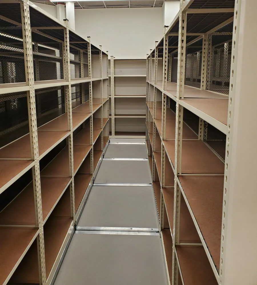 Single moving aisle opened between two runs of mobile stockroom shelving