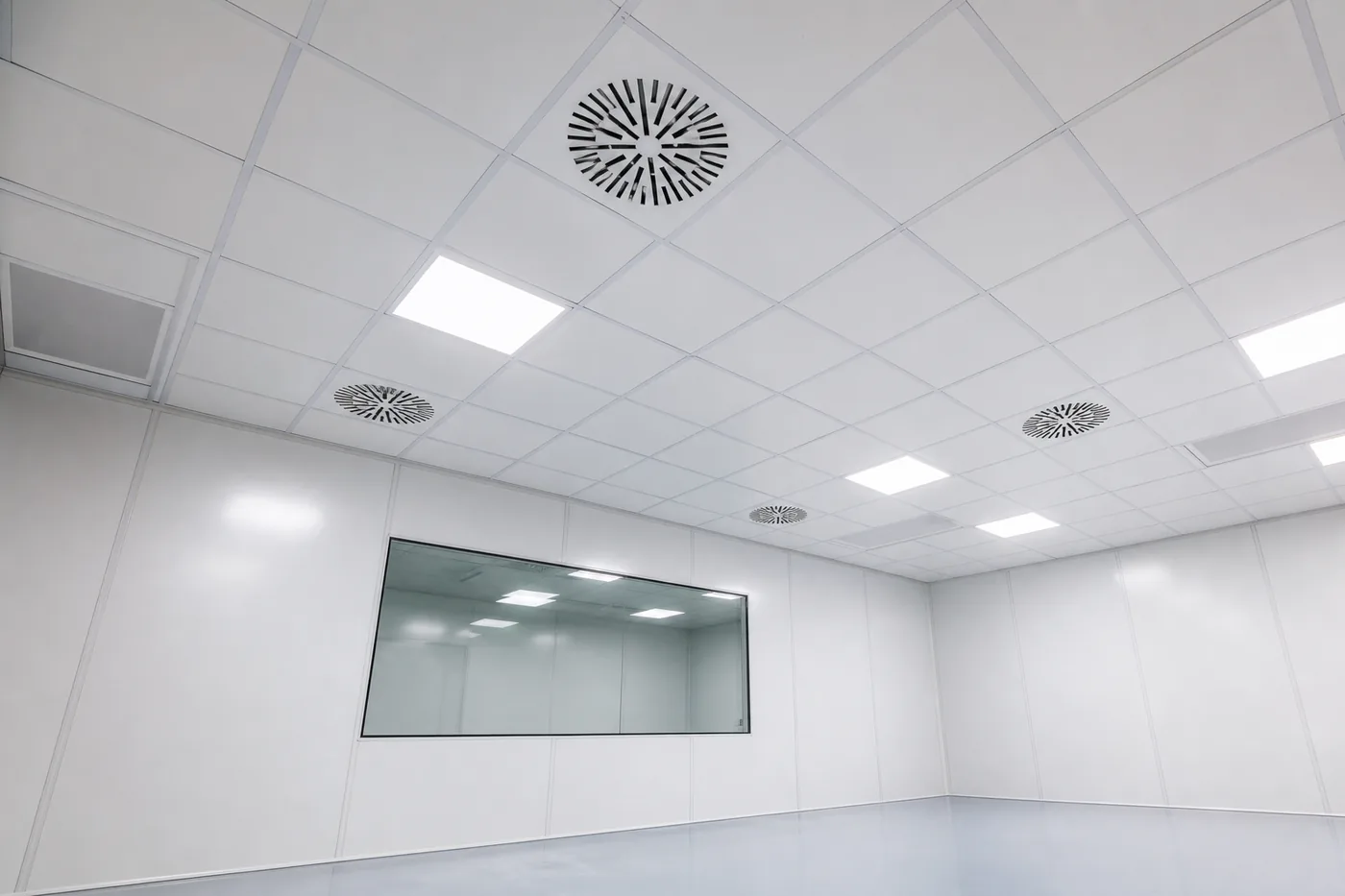 Ceiling of a controlled-environment modular room with filtered supply air diffusers and a vision window