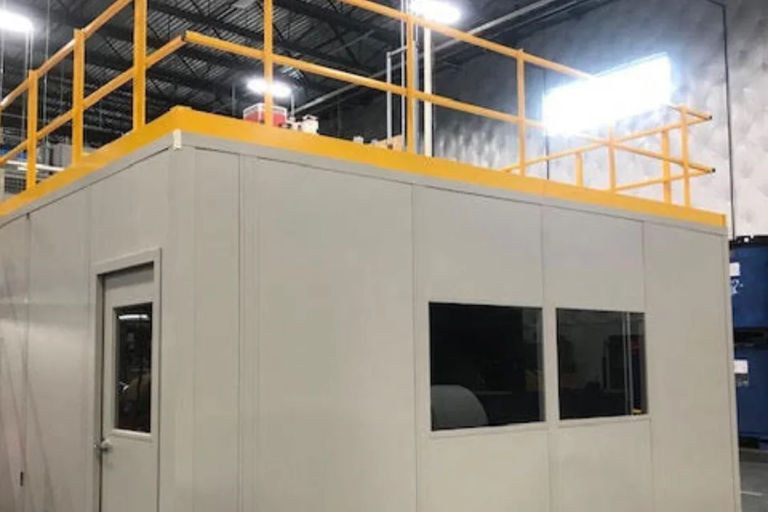 Modular in-plant office with a load-rated storage roof and yellow guardrail around the upper deck