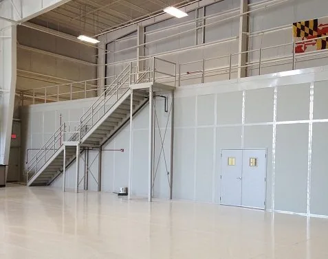 Two-storey modular in-plant enclosure with an external steel stair and upper-level glazing