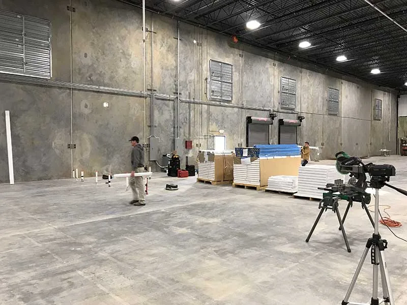 Installation crew laying out modular office wall panels on a plant floor before assembly