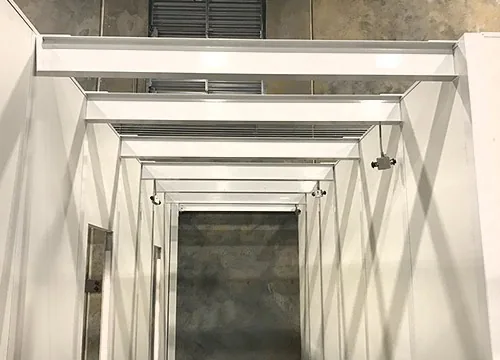 Interior steel beam framing above a modular in-plant enclosure ceiling