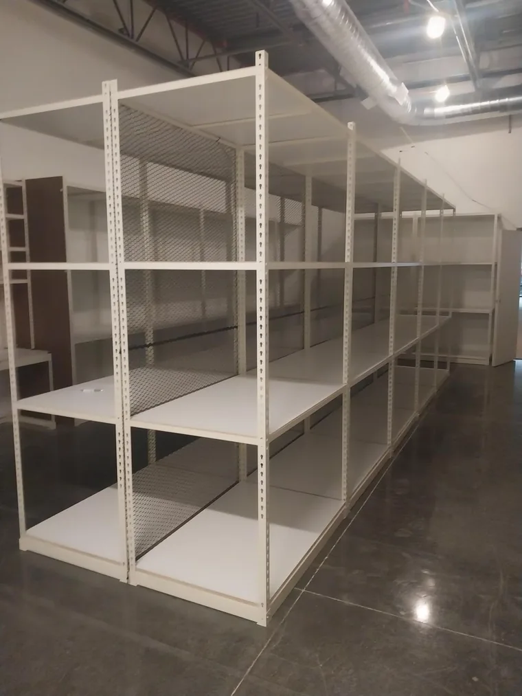 Long run of boltless rivet shelving with solid decks installed in a retail stockroom