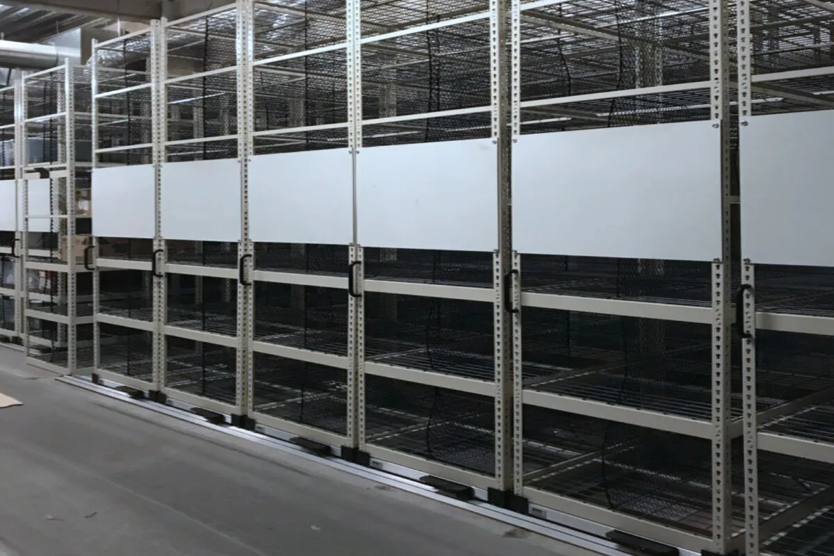 Rows of stockroom shelving with solid steel decks in a retail back-of-house area