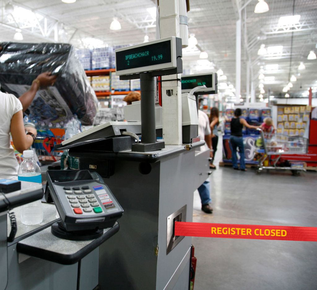 Retractable barrier closing a retail checkout lane