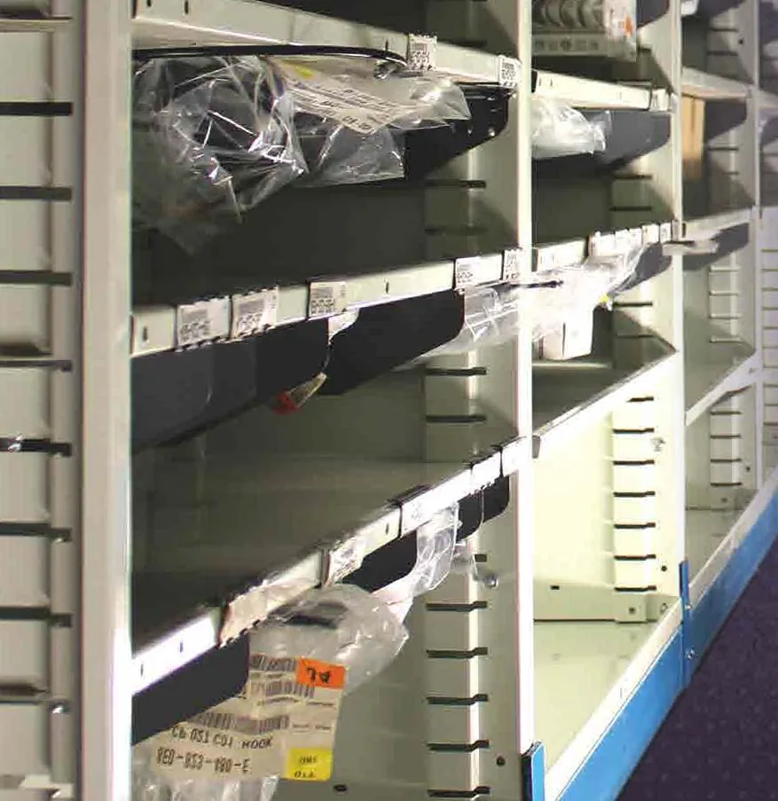 Bar-code labels on Borroughs Flexi-Bin sliding dividers above bagged parts on open shelves