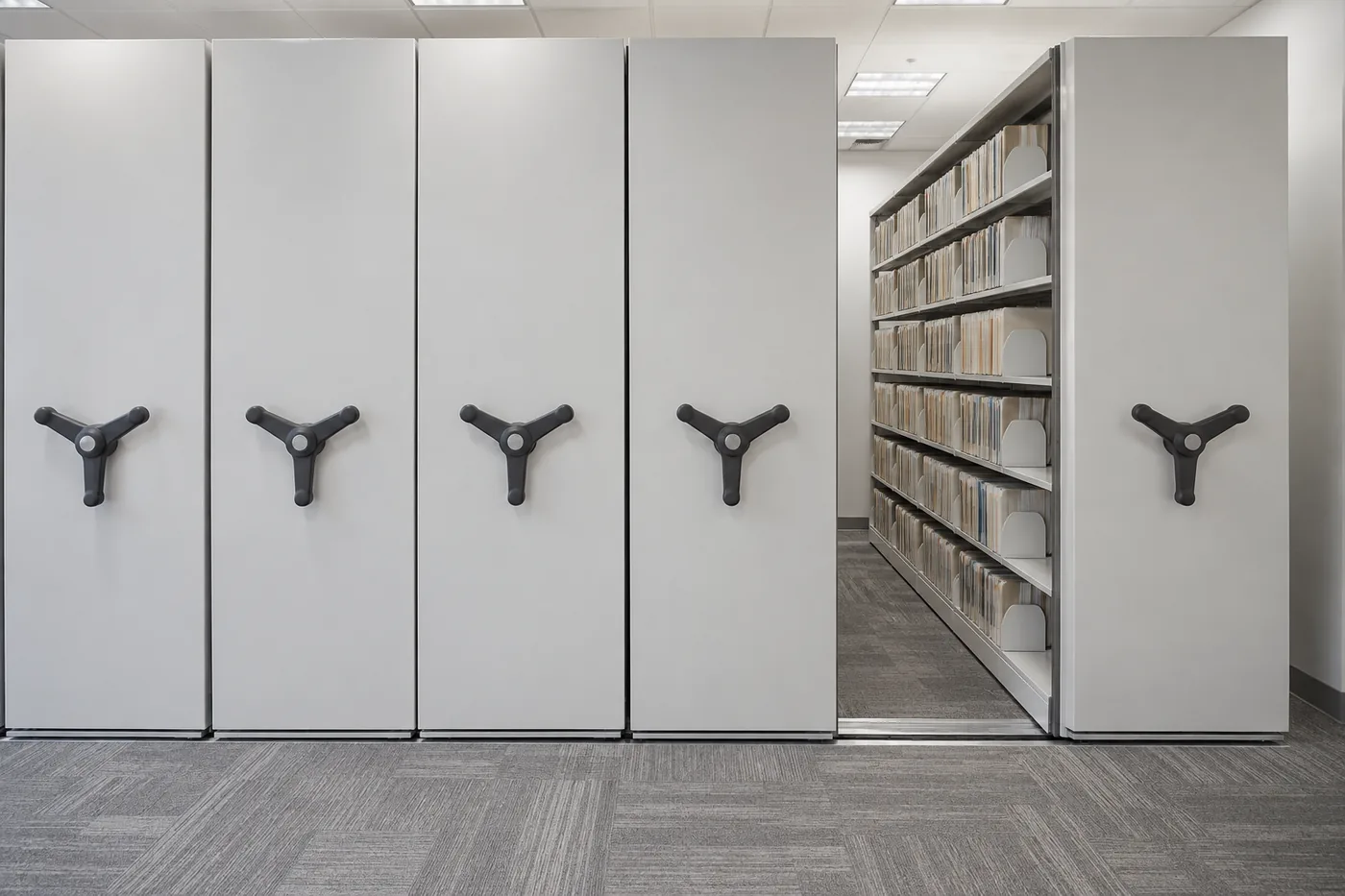 Front-facing high-density mobile shelving carriage ends with drive handles in a records file room