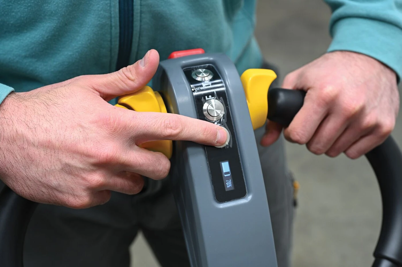Operator using the control handle of a Vestil EPT-CFR pallet truck