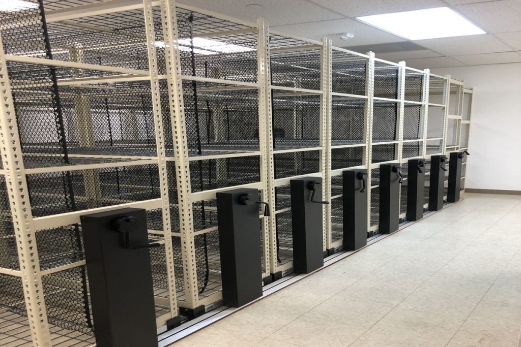 MMI mechanical-assist mobile shelving carriages closed in a corridor with wire shelves