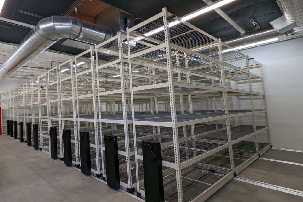MMI wire mobile shelving on mechanical-assist carriages closed along a corridor