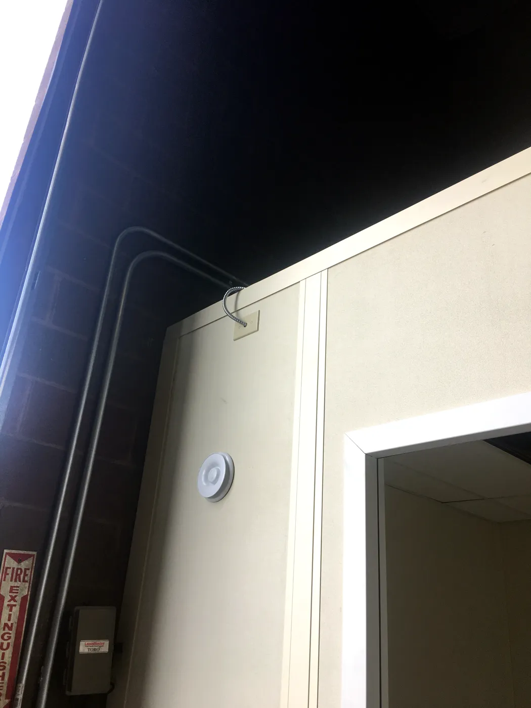 Exterior corner of a modular change room with surface conduit feeding power into the wall panel system