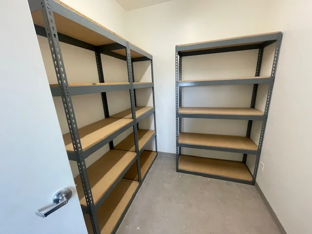 Two freestanding boltless shelving units on facing walls of a storage room at Ogden Housing Authority, Ogden, Utah