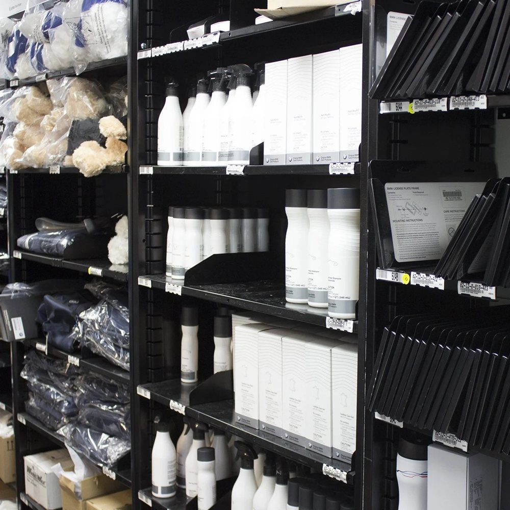 Black Borroughs shelving holding bottles and folded merchandise