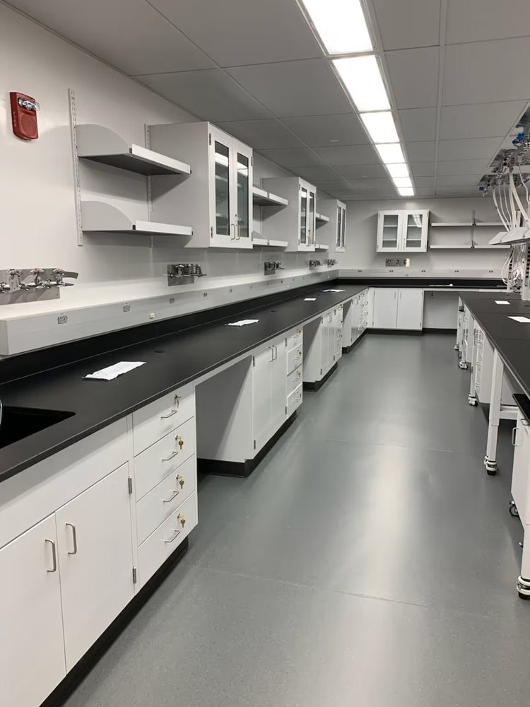 Long ICI laboratory worktop with white base cabinets and overhead storage
