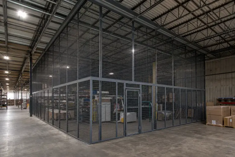 Large warehouse wire mesh security cage with panels extended to the roof deck
